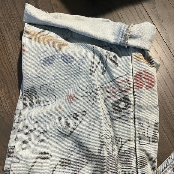 Light wash boyfriend style jean with graffiti details and folded ankle bottom. - Picture 2 of 3